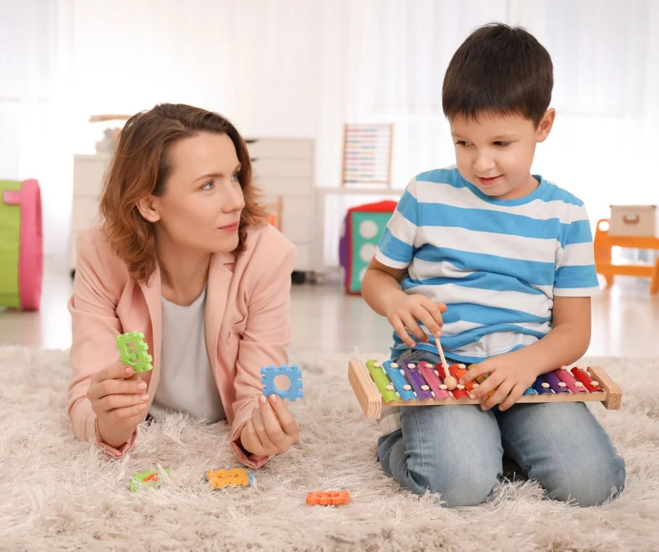 Una adulta acompañando a un niño en una actividad de juego